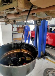 Used oil getting removed from vehicle at car workshop