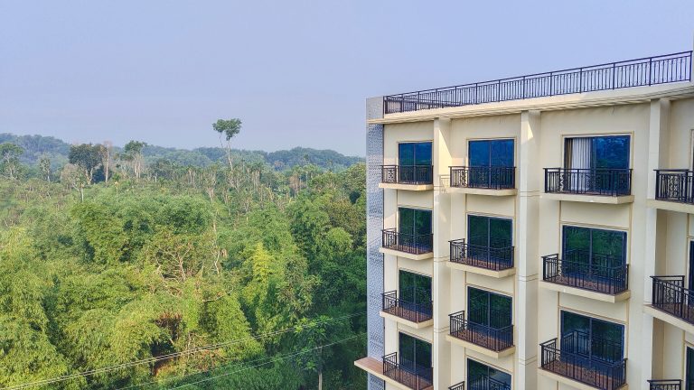 High-rise building with black iron balconies besides the Radanogor forest