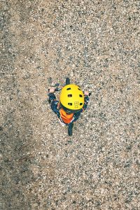  View larger photo: Kid on bike with yellow helmet on gravel, bird-eye view