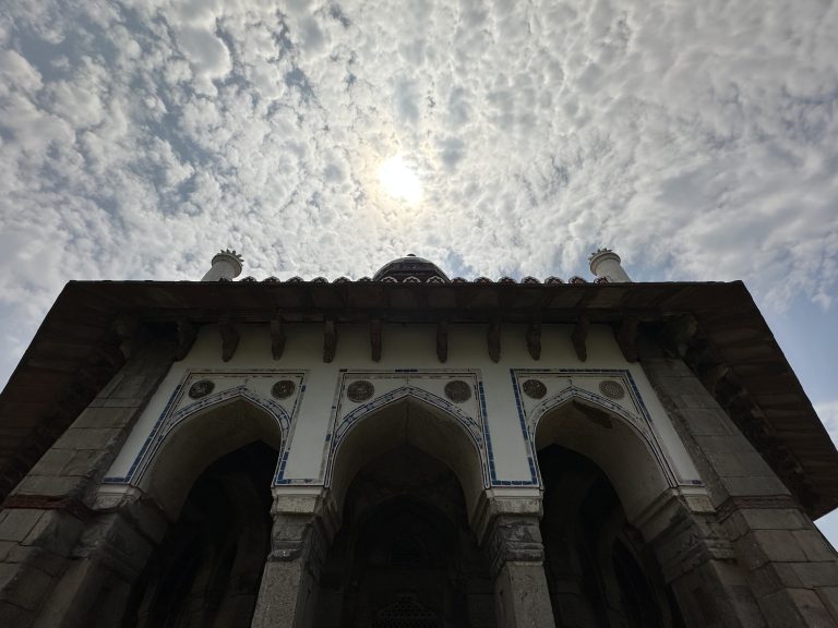 View of Isa Khan’s Mosque from the ground looking up at a sunny and cloud sky (New Delhi, India)