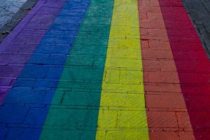 View larger photo: A city street with a rainbow painted on it.  The rainbow stripes run the full length of the image and all are 10s of centimeters wide