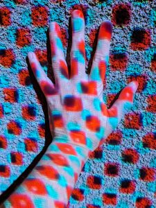 View larger photo: A hand against the wall with blue and red light dots.