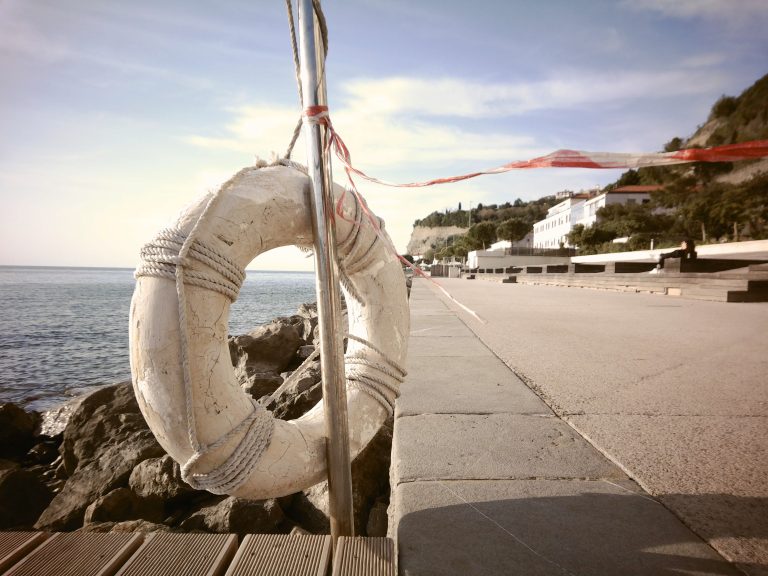 Lifesaver on a rail with a pathway leading out into the distance.