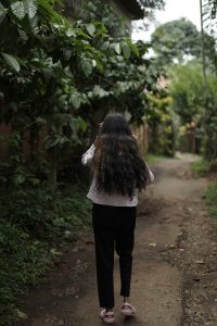 A women walking through a forest.