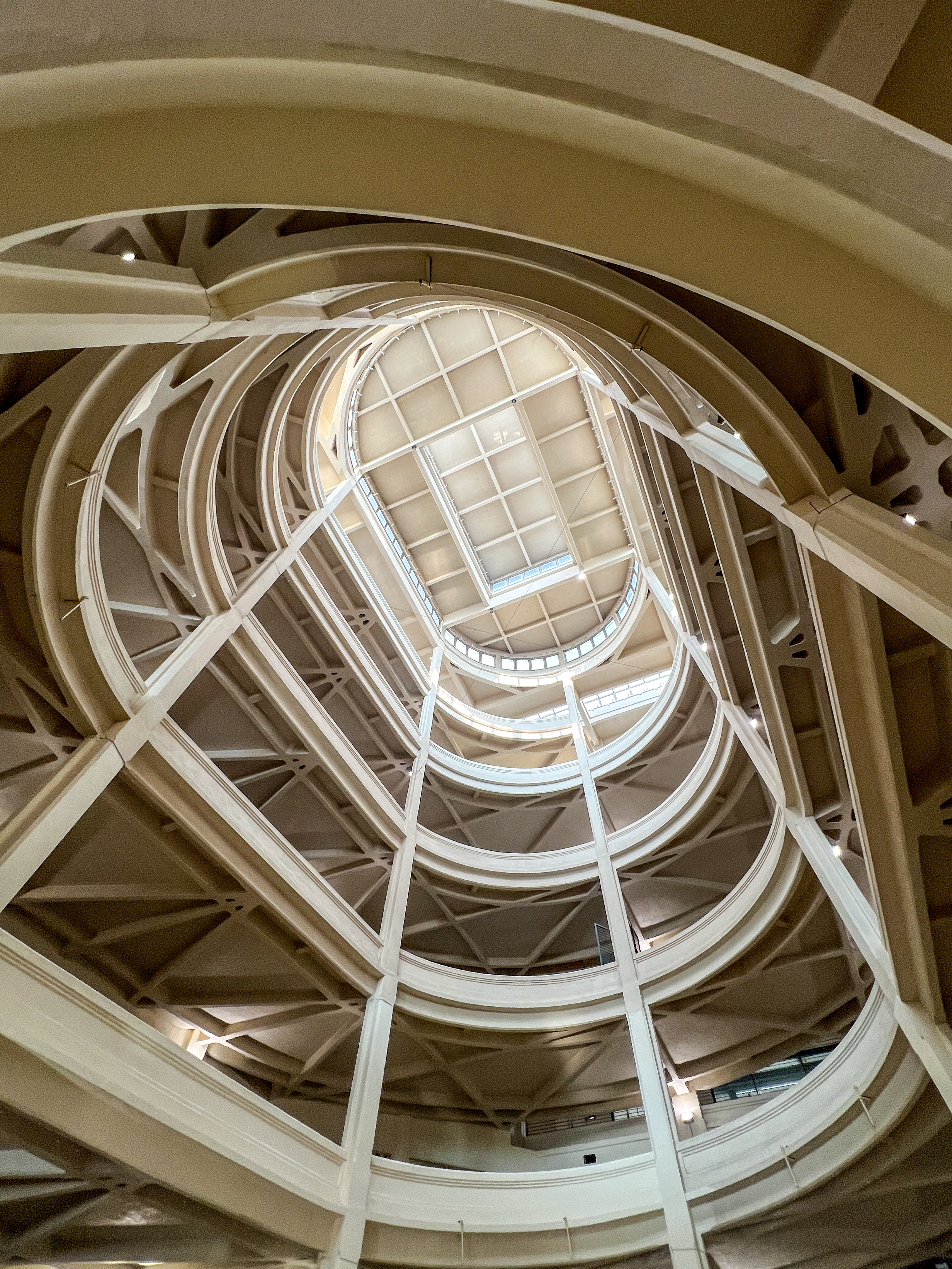 Looking up at the skylight in Lingotto Centro in Torino, Italy. A track spirals down, that used to be the exit for Fiats from the roof test track to the ground floor, now a walkway for pedestrians.