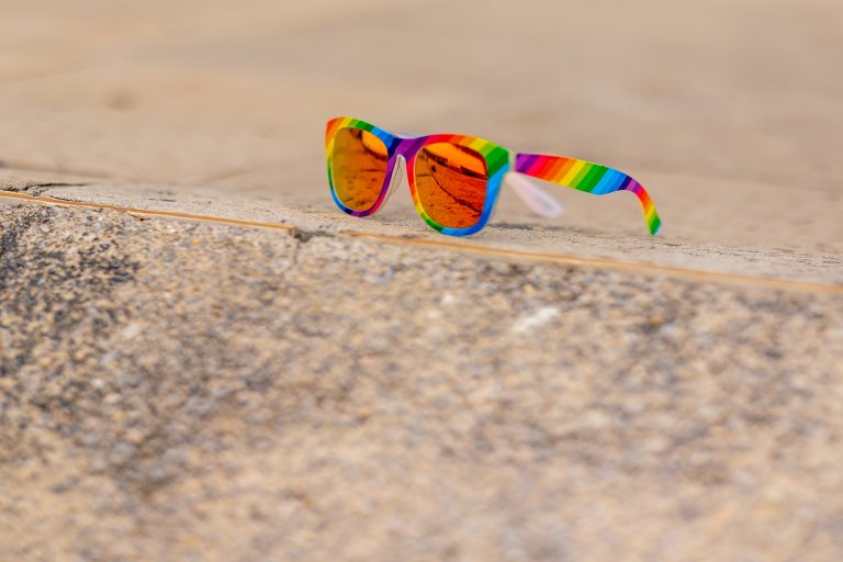 Rainbow mirrored sunglasses sitting on the ground