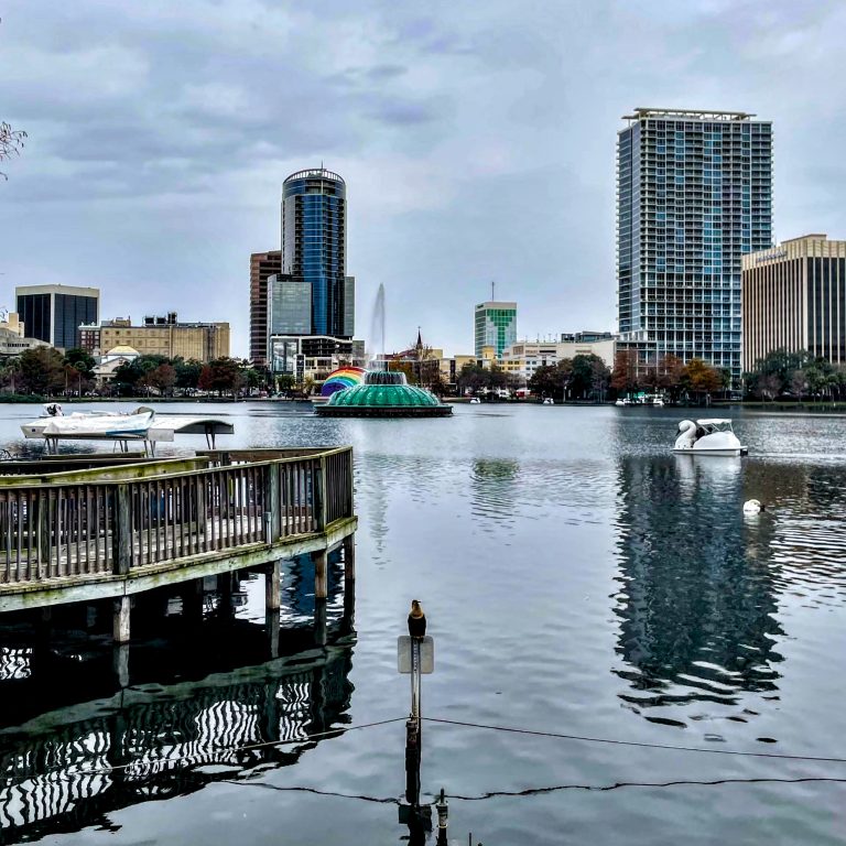 Lake Eola in downtown Orlando, showing part of the Orlando skyline, the Lake Eola fountain, a swanboat, and the rainbow ampitheater.