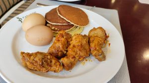 美味的鸡腿、煮鸡蛋和煎饼放在盘子里作为早餐。