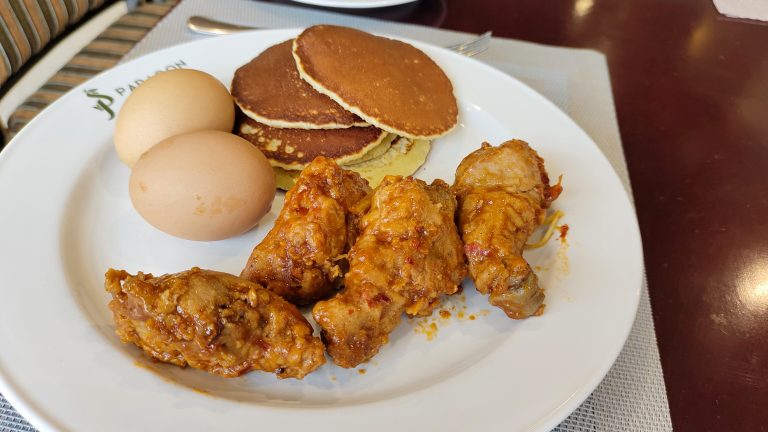 Delicious chicken leg, boiled eggs, and pancakes on a plate for breakfast.