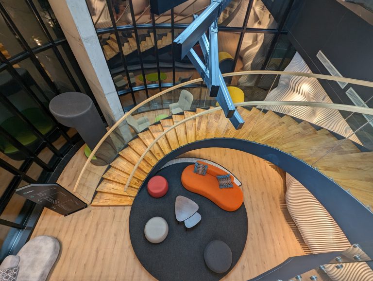 View of office stairs from the top and sitting chairs in between.