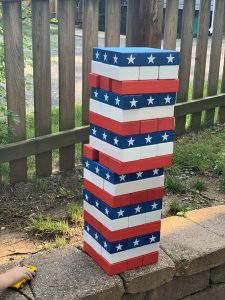 Outdoor oversized Jenga set decorated in red, white, and blue with with star designs