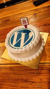White forest Cake made on occasion of WordPress anniversary with logo printed on of cake.
