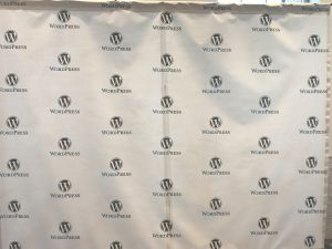 View larger photo: Photo opportunity background showing a repeating WordPress logomark in black on a white background