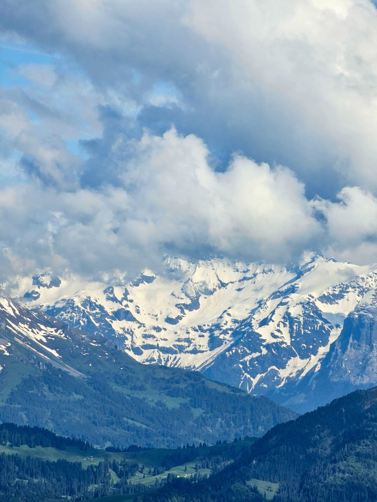 Long view of snowy mountain peaks, valley
and clouds. From Mount Pilatus, Switzerland