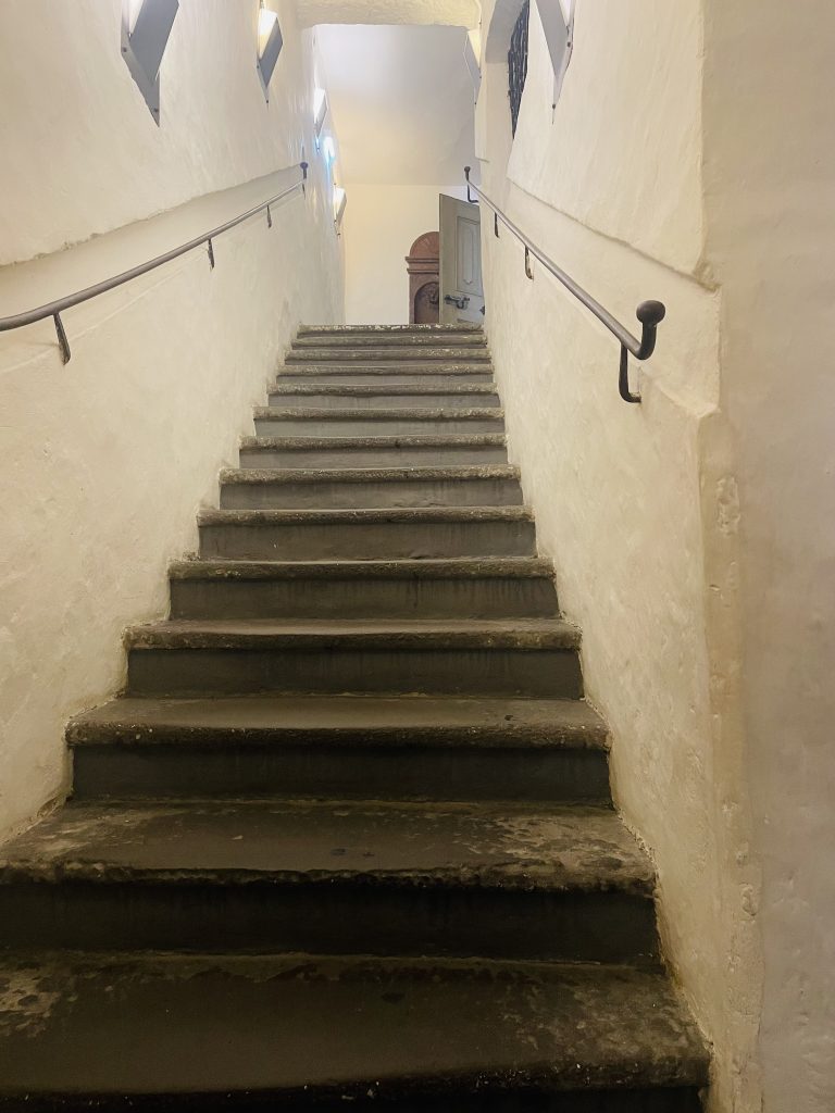 Old stone staircase located in the mozart museum, salzburg. White wall line the staircase