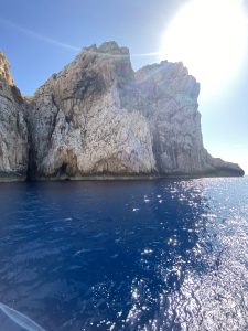 Ricky cliff coming out of deep blue water in the Sardinia Sea.