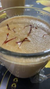 Several threads of saffron floating on top of the milky foam of a cup of tea.