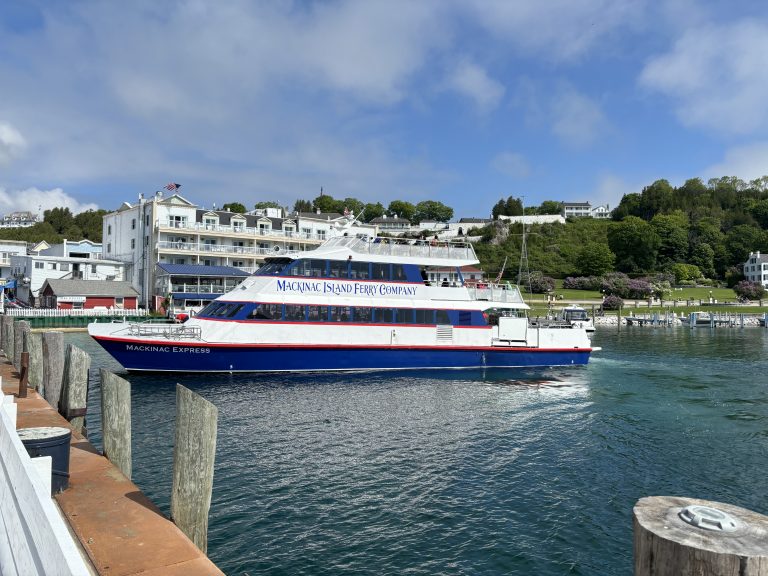 Mackinac Island ferry coming in to dock with the Pink Pony hotel behind it.