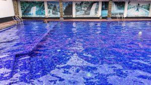 View larger photo: A large, clear blue swimming pool with tile steps. 