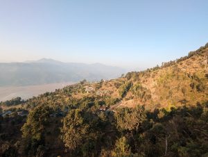 View larger photo: The Himalayan mountains seen from Sarangkot Pokhara, Nepal. A road and some buildings can be seen on the nearest slope.