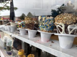 Ice cream cones with various decorations in a window, waiting to be picked by customers.