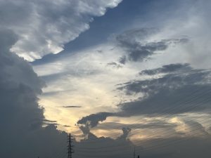 Sunset hidden by Clouds, power lines in the lower part.