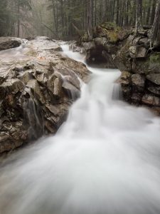 View larger photo: A long exposure photo taken on a rainy day of a small waterfall on the Pimegewasset River in Franconia Notch State Park, New Hampshire.