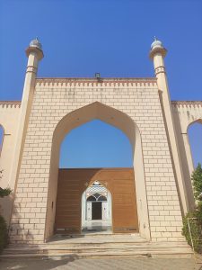 The entrance to a mosque, photographed on a sunny day with a clear blue sky.