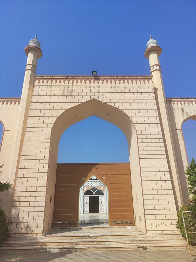 The entrance to a mosque, photographed on a sunny day with a clear blue sky.