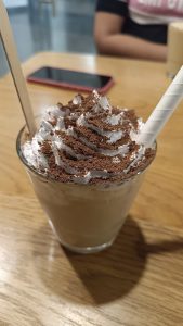 Cold coffee with cream and chocolate powder decoration