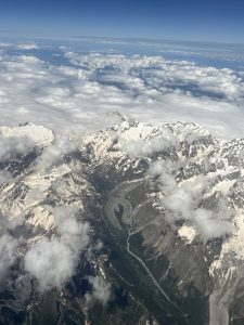 Aerial shot of the Alps. A river running through a valley is visible in the foreground.