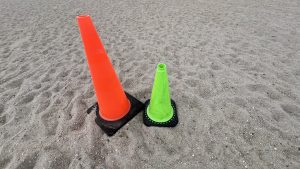  One large neon orange and one small neon yellow traffic cone on a beach (Lewes Public Beach, Delaware)
