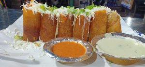 View larger photo: Jini Dosa, vegetable-filled dosa rolls, with two sauces in tin foil cups.