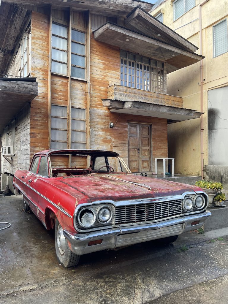 Rusty classic car in front of the house