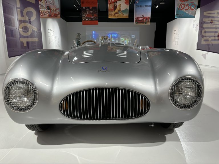 A sleek silver sportcar, convertable, very low to the e ground, seen from the front. National Museum of the Automobile, Torino, Italy