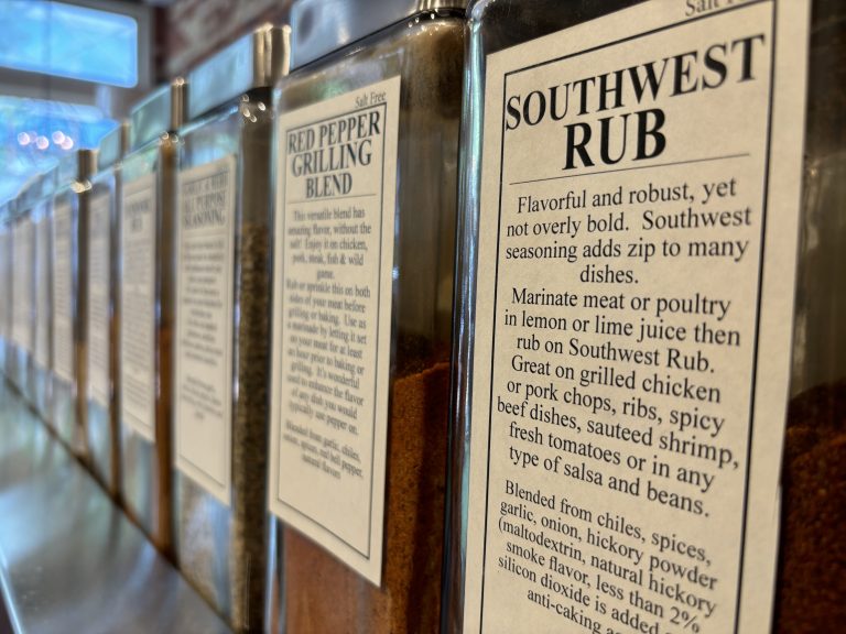 A row of spices on a rack. The jar that’s closest to the camera is in focus.