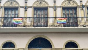 View larger photo: Two pride flags on the railing of a balcony.