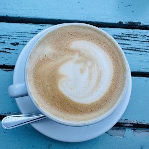  A cup of coffee on a bright blue table.
