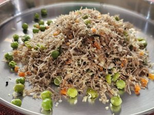 View larger photo: A plate of rice noodles (Vermicelli) topped with green peas and chopped carrots.