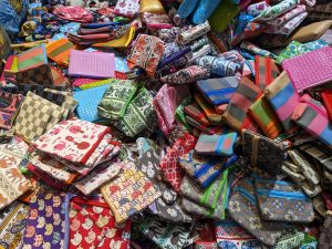 View larger photo: A lively jumble of colorful fabric pouches with all sorts of patterns—stripes, checks, and quirky cartoons—piled high like a treasure hunt in the heart of Bangkok's Chinatown.