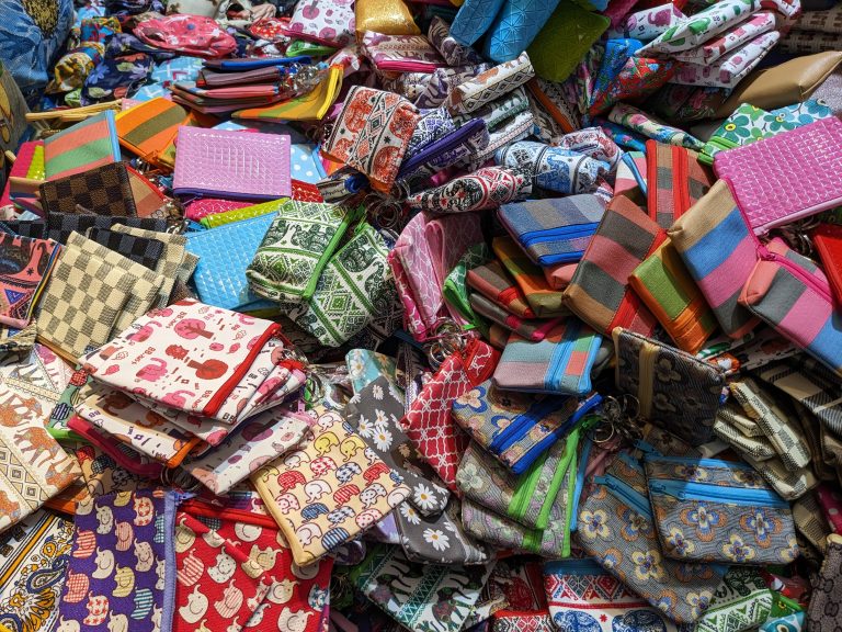 A lively jumble of colorful fabric pouches with all sorts of patterns—stripes, checks, and quirky cartoons—piled high like a treasure hunt in the heart of Bangkok’s Chinatown.