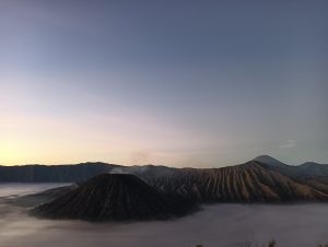 View larger photo: Gunung Bromo dari Spot Penanjakan, Mount Bromo from the Penanjakan Spot. Long view, well above the clouds of what appears to be a volcano in the distance.