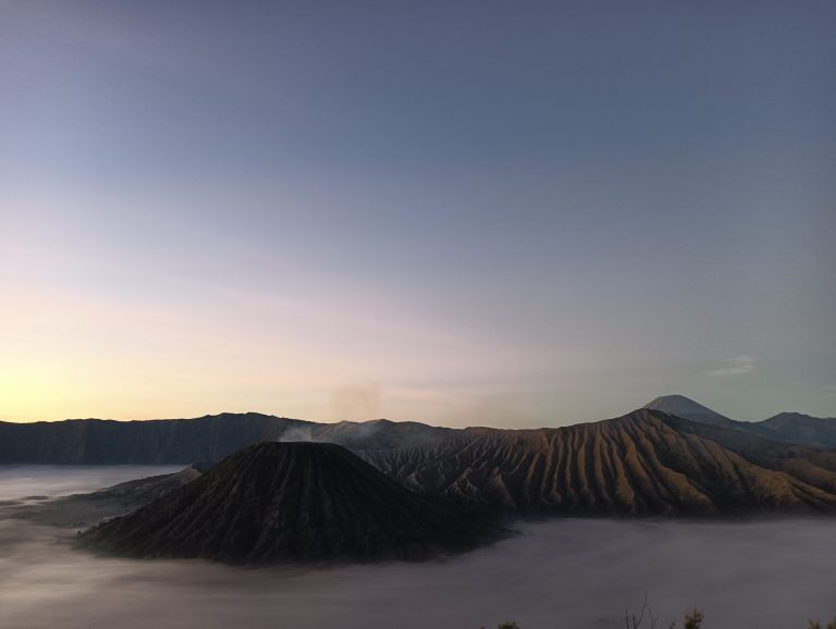 Gunung Bromo dari Spot Penanjakan, Mount Bromo from the Penanjakan Spot. Long view, well above the clouds of what appears to be a volcano in the distance.