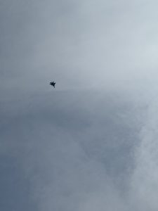 View larger photo: A US fighter jet against a blue sky with whispy clouds.