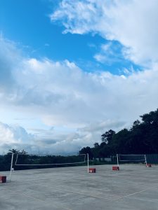 View larger photo: Badminton courts with a bright blue sky with wispy clouds.