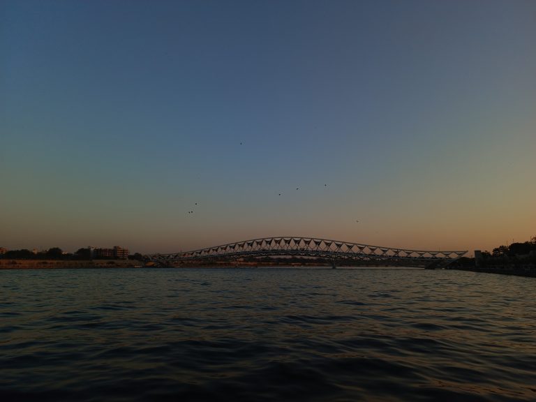 Where the bridge meets the river and the sky.