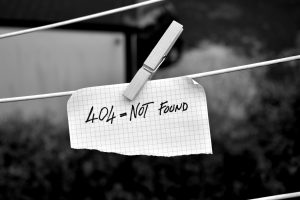 This is a piece of paper hanging from a clothesline with a clothespin. It represents the 404 error encountered by those who cannot find something on a website. Format 2/3, black and white.