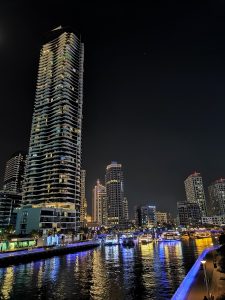 View larger photo: Brightly lit river in downtown Dubai at night with towers on either side.