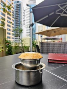 View larger photo: Filter Coffee, served on a terrace at the Dubai Marina. Several buildings can be seen in the background.