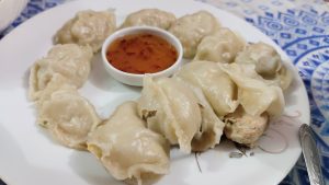 View larger photo: A tempting plate of dumplings served with a side of flavorful dipping sauce for a perfect bite.